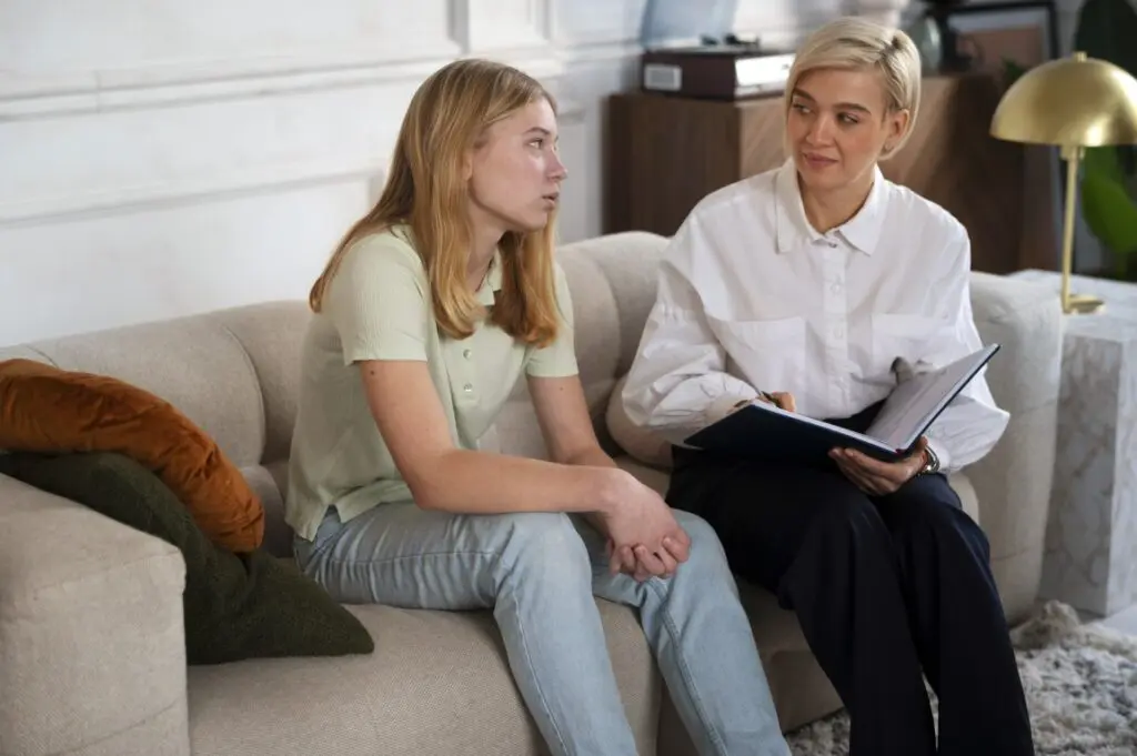 Counselor talking with a young girl during a depression support session