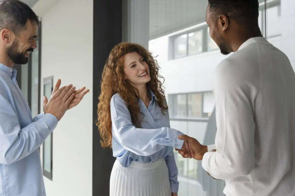 Woman shaking hands with a man during an assertiveness and self-confidence counseling session.
